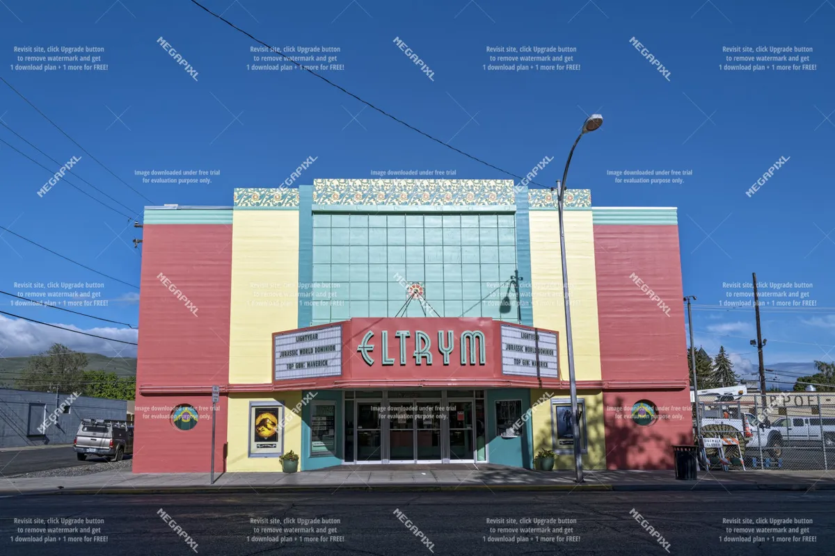 The Eltrym Theatre's art deco marquee stands out against a colorful facade, hinting at classic movie nights and special community events. The street scene is animated and nostalgic, suggesting a unique local attraction steps away from accommodations.