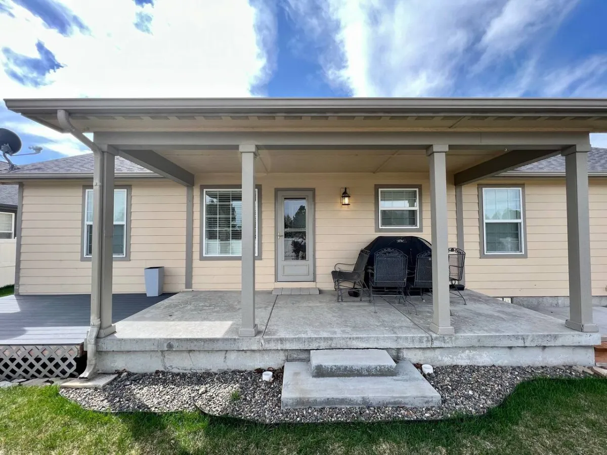 This image captures the home's front porch, featuring a cozy seating area and inviting doorway. The space is bathed in natural light, suggesting a place to enjoy a morning coffee or unwind after a day of exploring Baker City's heritage sites.